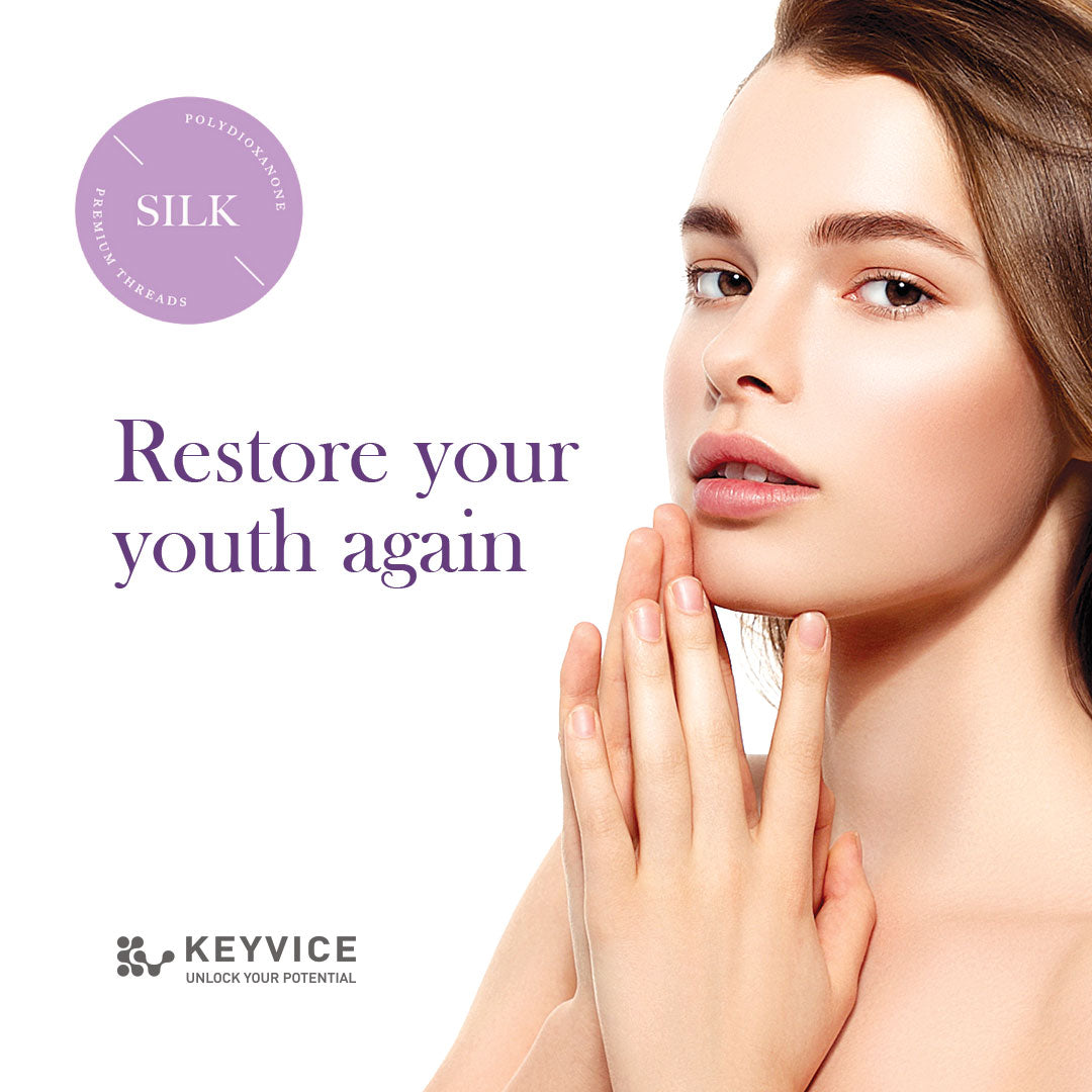Promotional image for Silk PDO Threads featuring a close-up of a young woman with flawless skin and hands gently touching her face, alongside the text 'Restore your youth again' and the Keyvice logo